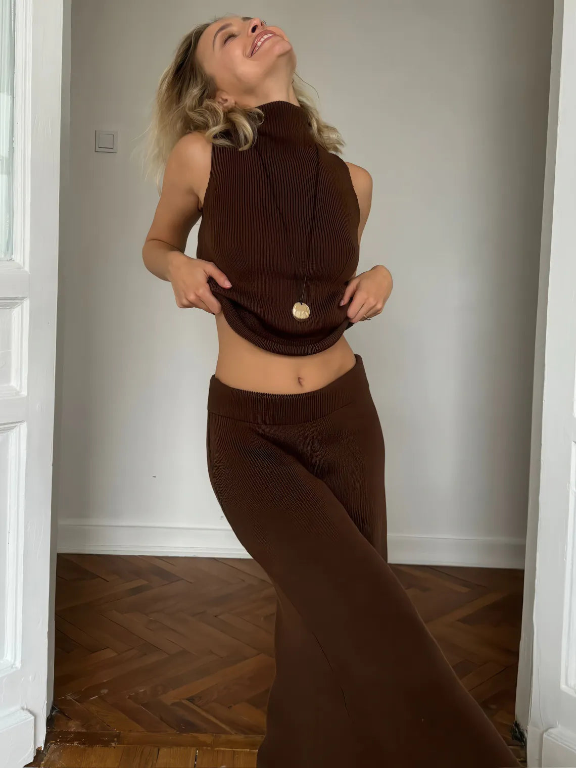 Woman wearing a brown ribbed outfit in a room with wooden flooring. #Color_Brown