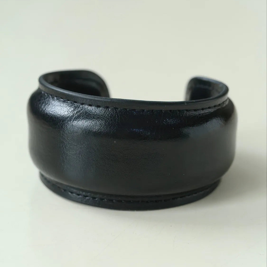 Black leather cuff on a light beige background