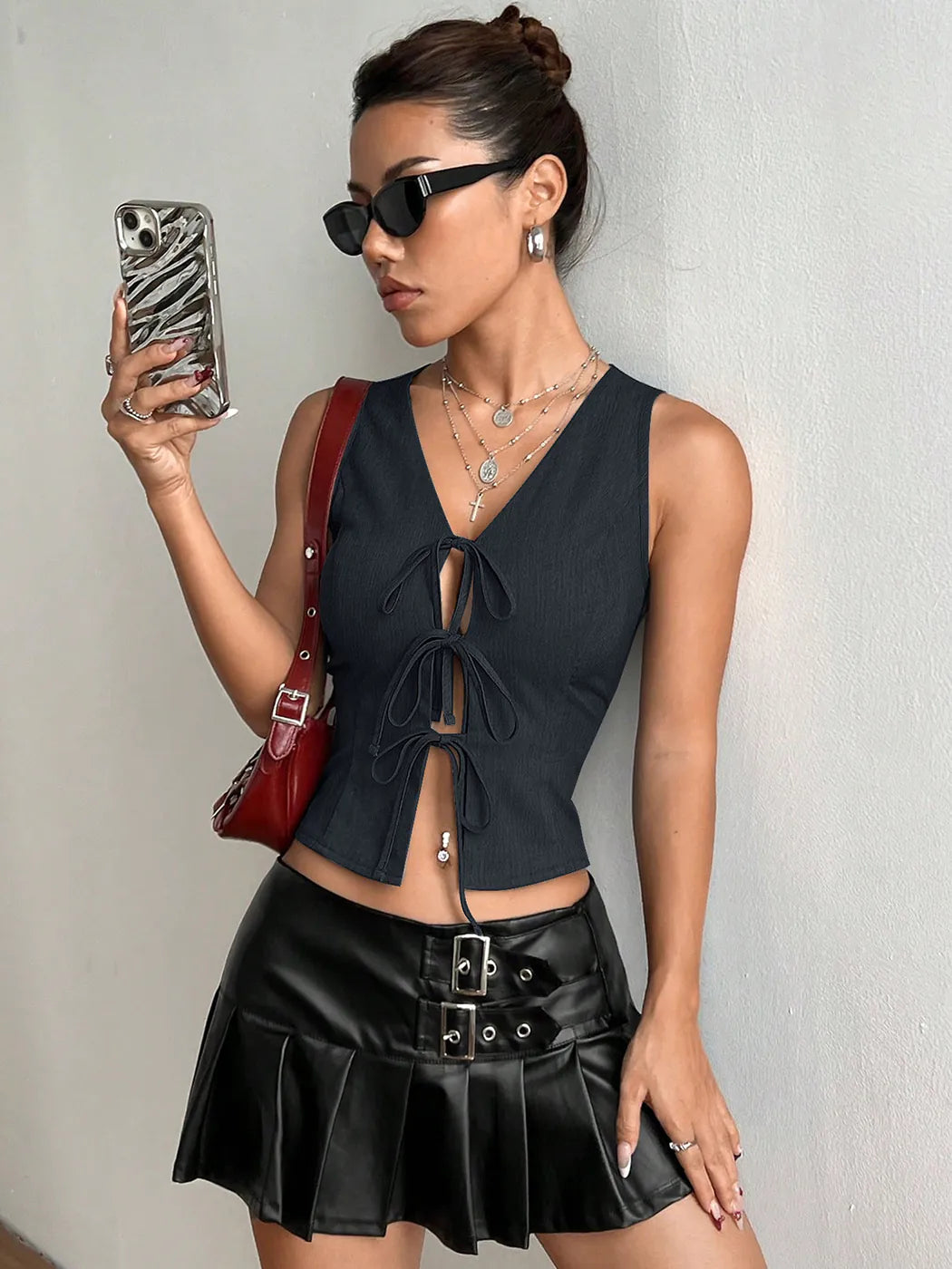 Woman in a gray top and black skirt holding a phone with a zebra case against a plain background #Color_MidnightBlue