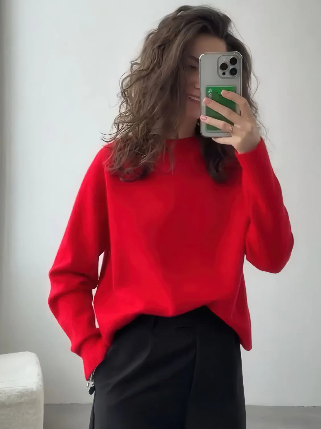 Person wearing a red sweater and black pants taking a mirror selfie. #Color_Red