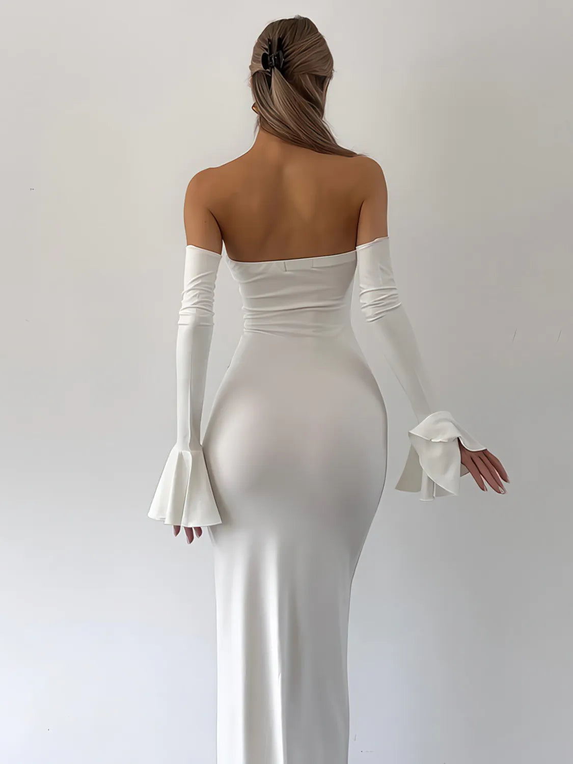Woman wearing a white evening gown with long gloves on a plain background. #Color_White