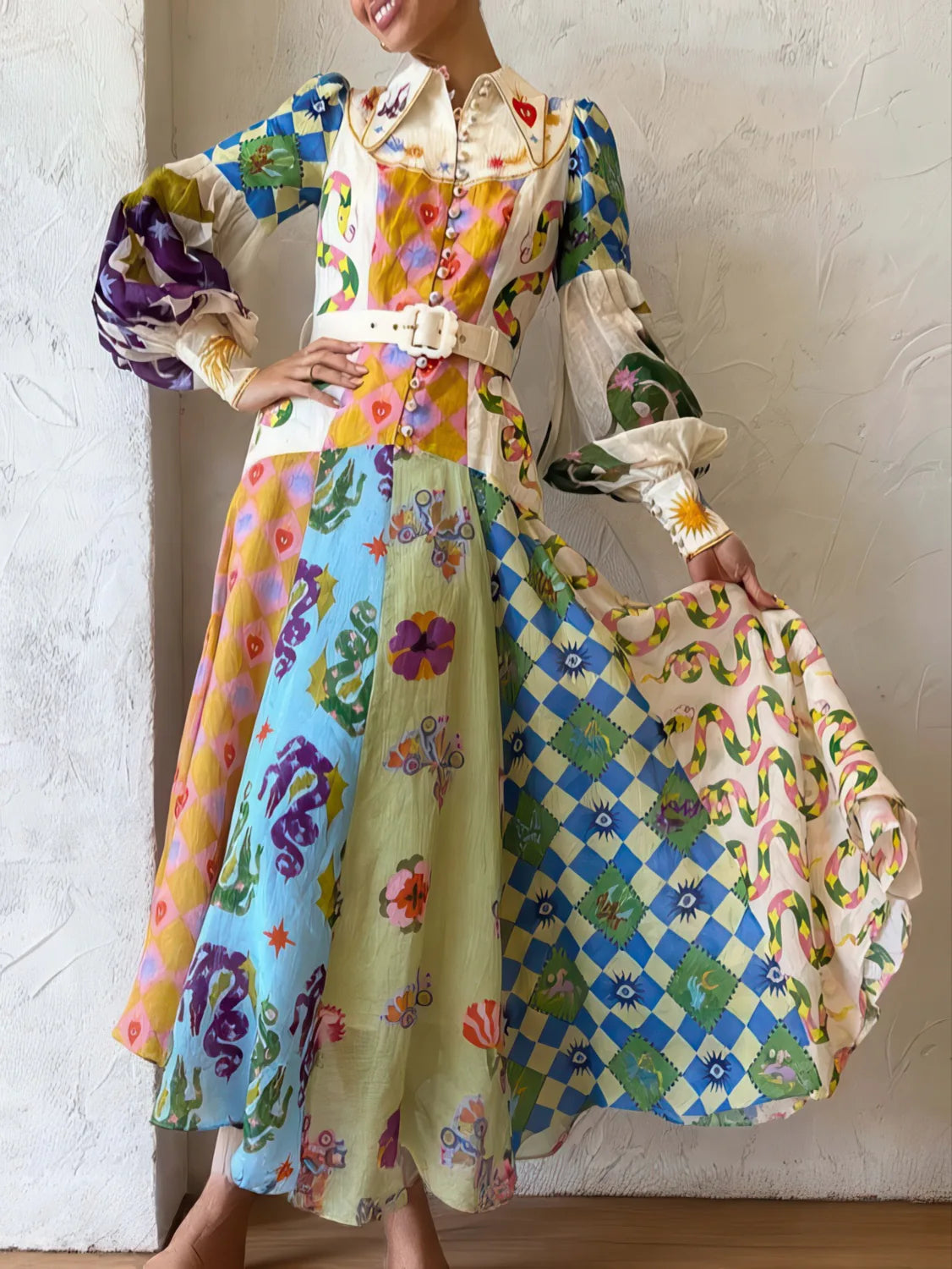 Woman holding a colorful patterned dress against a white wall. #Color_LightBlue