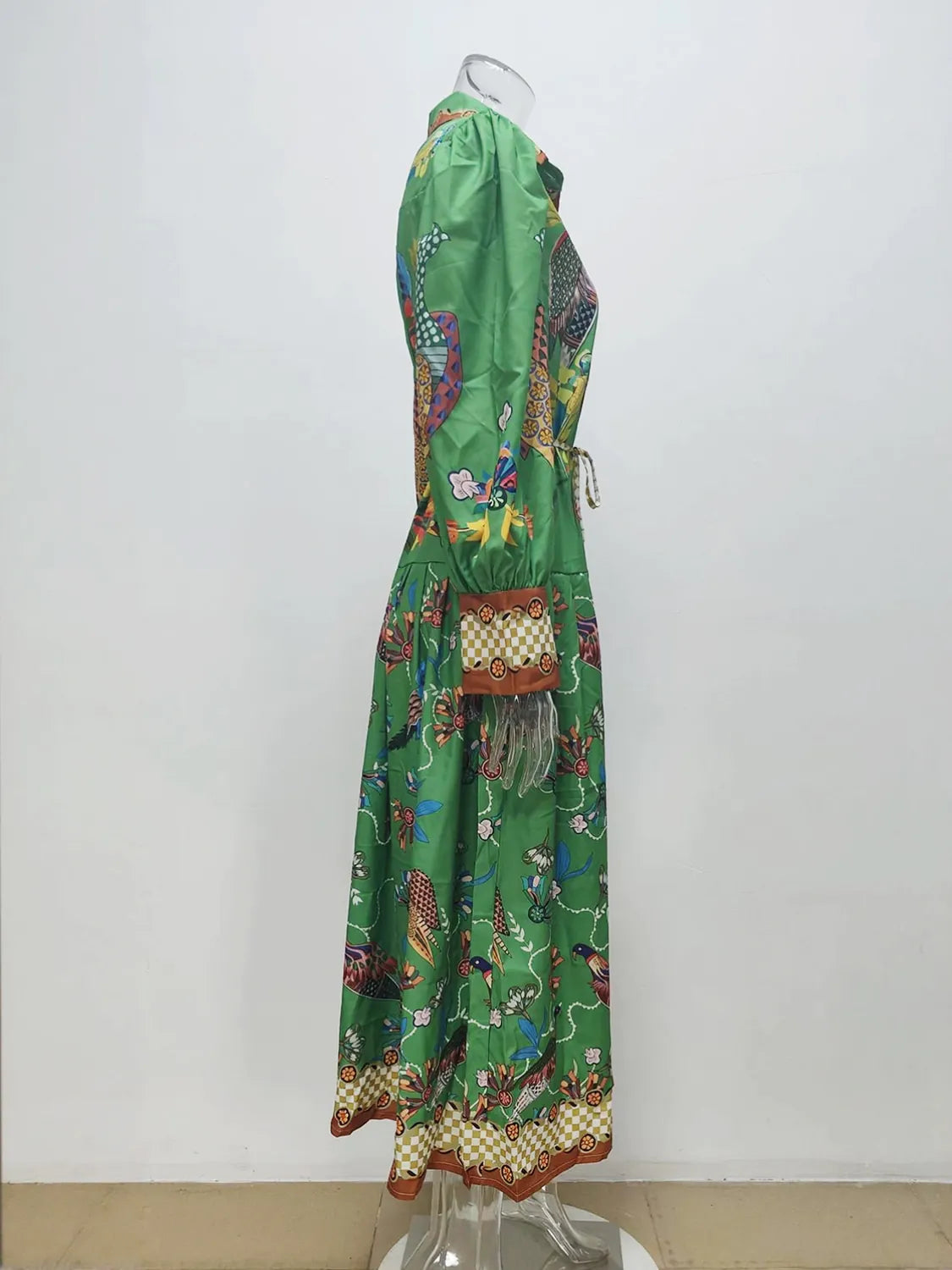 Green dress with colorful patterns on a mannequin against a white background. #Color_Green