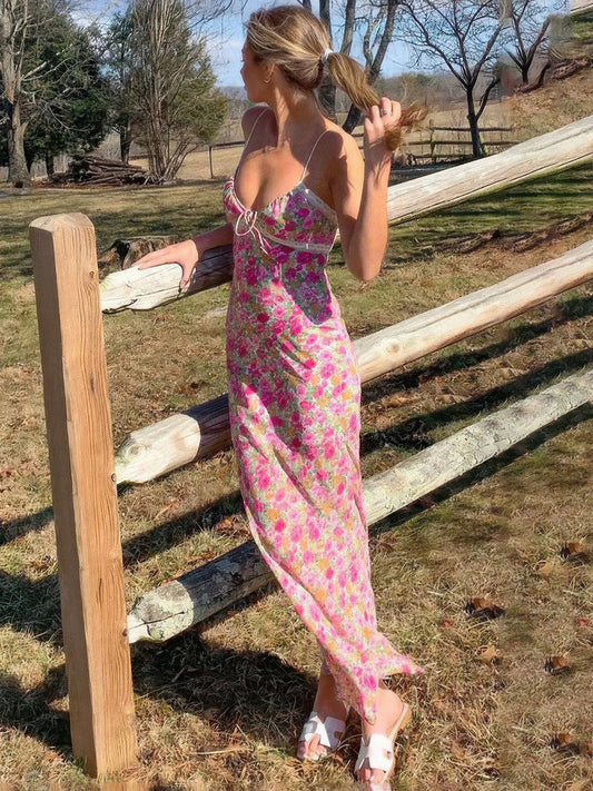 Woman in a floral dress standing near a wooden fence in an outdoor setting | IFAUN