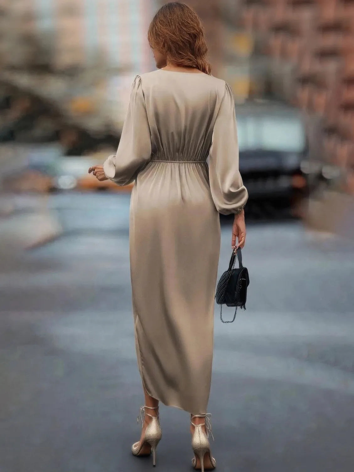 Woman in a beige dress walking on a street with blurred background