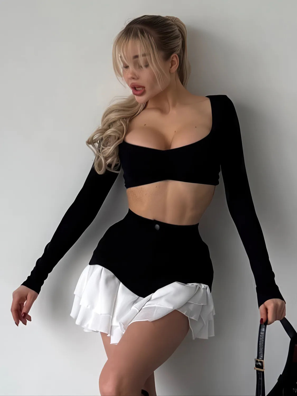 Woman wearing a black long-sleeve top and white skirt against a plain background. #Color_Black