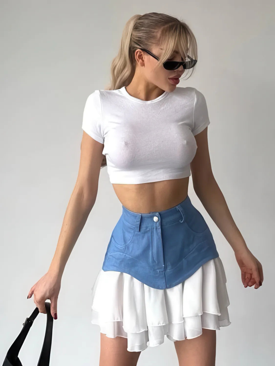 Woman wearing a white crop top and blue denim skirt against a plain background. #Color_Blue
