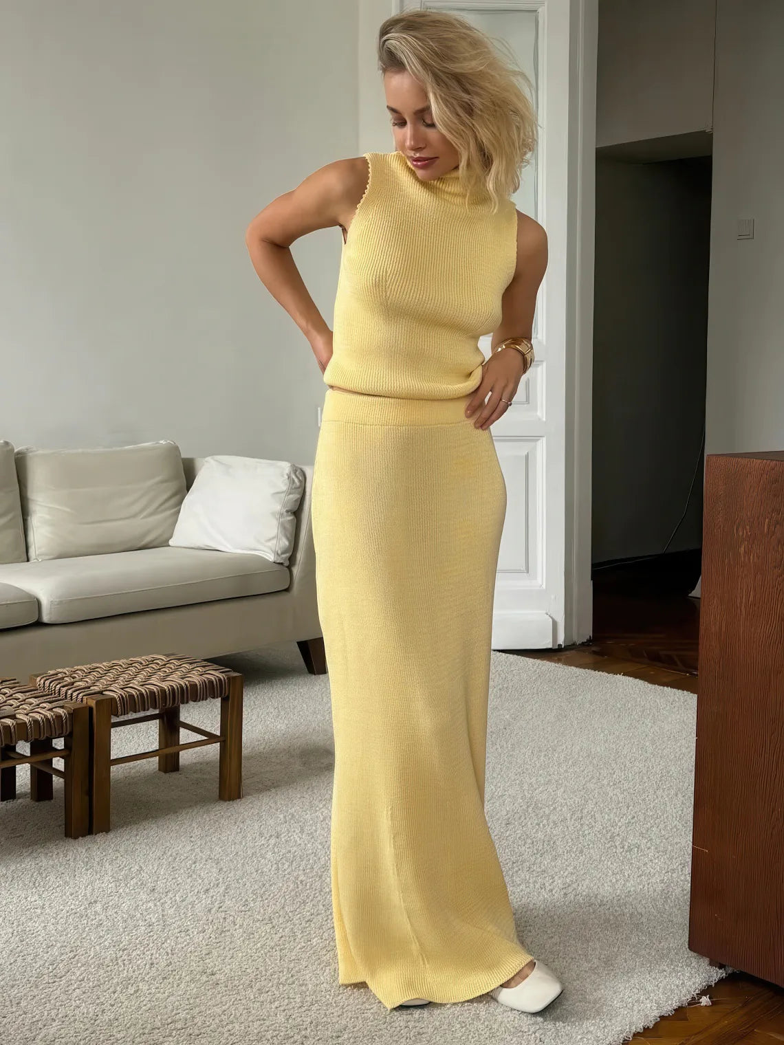 Woman in a yellow dress standing in a living room. #Color_Yellow